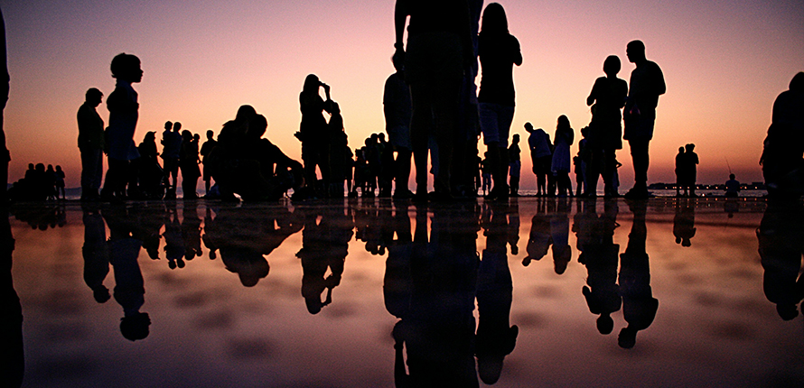 Silhouettes of people, reflected on water